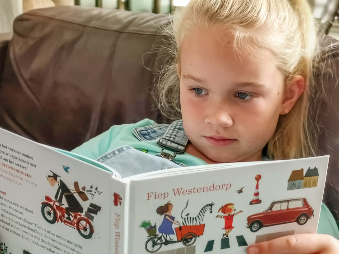Foto van meisje dat in het boek "Fiep in het verkeer" leest.