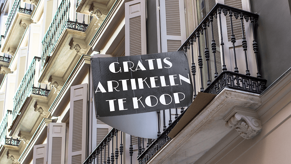 Frans balkon met aan het balkonhek een bord waarop "gratis artikelen te koop" te lezen staat als link naar artikelmarketing.